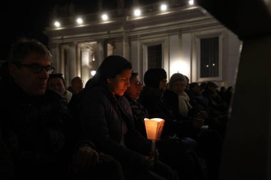 Vatikan Şehri, İtalya 03.03.2025: Rahibe elinde bir mum tutuyor ve diğer inananlarla birlikte, sekizinci gün, Aziz Peter Bazilikası 'nda Papa Francis için kutsal tespihi okuyor. Pope zatürreeden Gemelli Polikliniğine kaldırıldı
