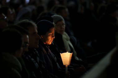 Vatikan Şehri, İtalya 03.03.2025: Rahibe elinde bir mum tutuyor ve diğer inananlarla birlikte, sekizinci gün, Aziz Peter Bazilikası 'nda Papa Francis için kutsal tespihi okuyor. Pope zatürreeden Gemelli Polikliniğine kaldırıldı