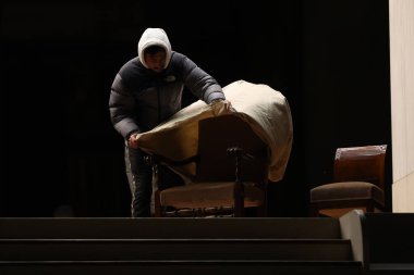 Vatikan City, İtalya 04.03.2025: bir işçi battaniye ile kaplar ve Aziz Peter Bazilikası 'nın önündeki meydanda Papa Francis için yapılan Kutsal Tespih duasından sonra sandalyeyi sunakta taşır. Papa Francis, Gemelli P 'de hastaneye kaldırıldı.