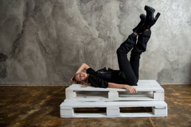 Stüdyoda poz veren siyahlı güzel sarışın kadın.