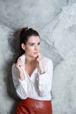 Gri duvara poz veren güzel esmer