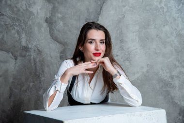 Stüdyoda gri duvara karşı poz veren güzel seksi kadın.