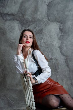 Stüdyoda gri duvara karşı poz veren güzel seksi kadın.