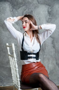 Stüdyoda gri duvara karşı poz veren güzel seksi kadın.