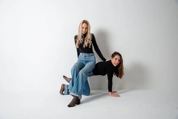Två Vackra Flickor Brunett Och Blond Poserar Studio Mot Grå — Stockfoto