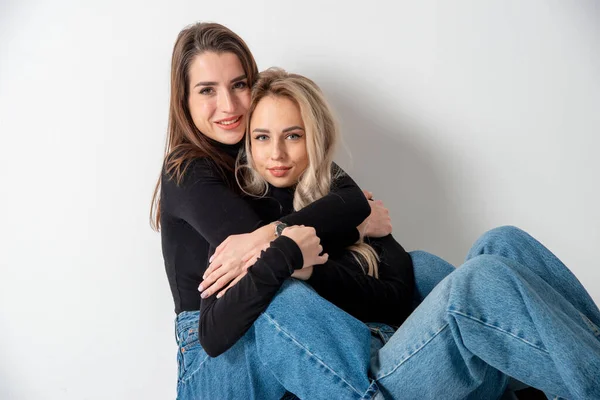 Två Vackra Flickor Brunett Och Blond Poserar Studio Mot Grå — Stockfoto