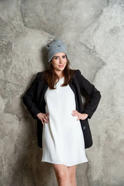 Красивая Молодая Женщина Позирует Студии Белом Платье Черной Куртке Серой — стоковое фото