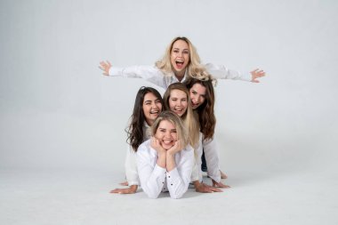 young attractive women in white shirts and jeans posing in the studio