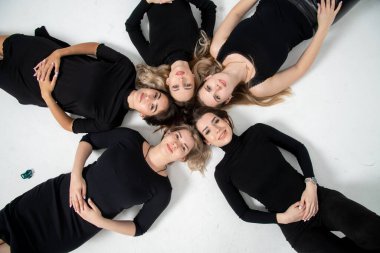 Group of young women lying in a circle, laughing, hugging, having fun, hands