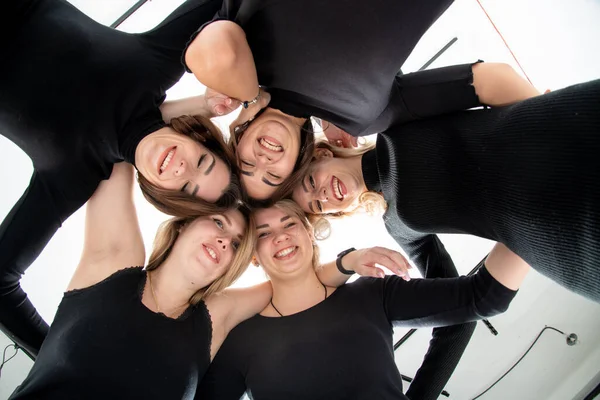 Group of young women standing in a circle, laughing, hugging, having fun, hands