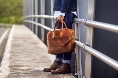 Deriden yapılmış ürünler. Minimalist tarzda kahverengi deriden yapılmış çanta ya da askı çantası ya da minimalist ve lüks retro renkler. Deri cüzdan.