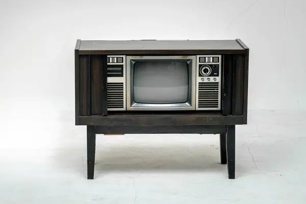 Retro old television with clipping path isolated on white background. TV stand and blank screen, with vintage radio and telephone, technology.