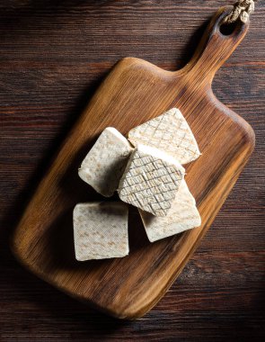 Ahşap kesim tahtasındaki çiğ tempeh ya da tempo, ahşap bir arka planda izole edilmiş.