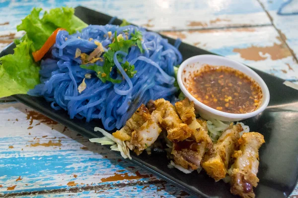 Purple Butterfly Pea Noodles with Crispy Pork in Chiang Mai, Thailand.