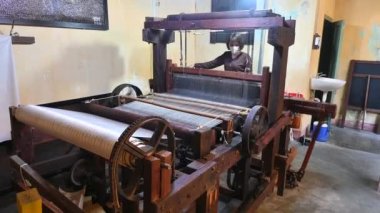 Hoi An, Vietnam: 13 Şubat 2023 - Vietnamlı kadın dokuma tezgahında el yapımı ipek dokuma ve iplik örüyor