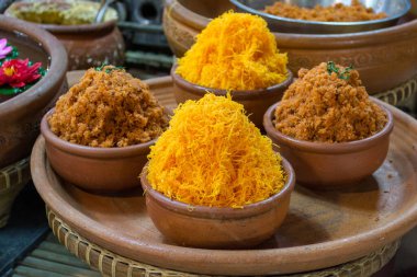 Altın yumurta sarısı iplikleri ya da muz yaprağıyla ahşap masada Foi Tanga. Yumurta sarısı ve şekerden yapılan ünlü ve lezzetli bir Tayland tatlısıdır..