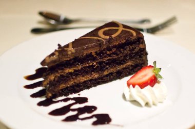 Çilekli ve kremalı bir dilim çikolatalı kek..