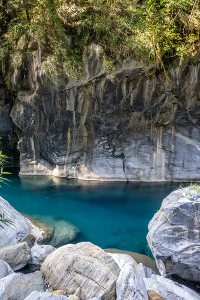 stock image A vibrant blue river flowing through a dramatic mountain canyon, showcasing the stunning natural beauty and dynamic landscape on Shakadang Trail in Taroko National Park, Hualien, Taiwan