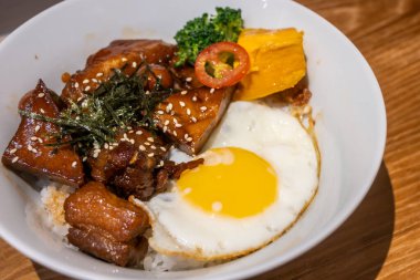 Tainan, Tayvan 'da sunulan tatlı ve lezzetli domuz eti göbeği, güneşli bir yumurta ve taze sebze içeren ağız sulandıran bir Asya yemeği. Öğle veya akşam yemeği için mükemmel..