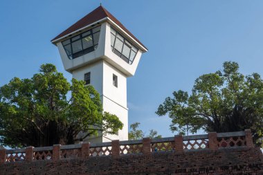 Anping Eski Kalesi 'nin çarpıcı beyaz kulesi, Tayvan, Tainan' da canlı bir mavi gökyüzüne kurulmuş yemyeşil bir arazinin ortasında duruyor. . 