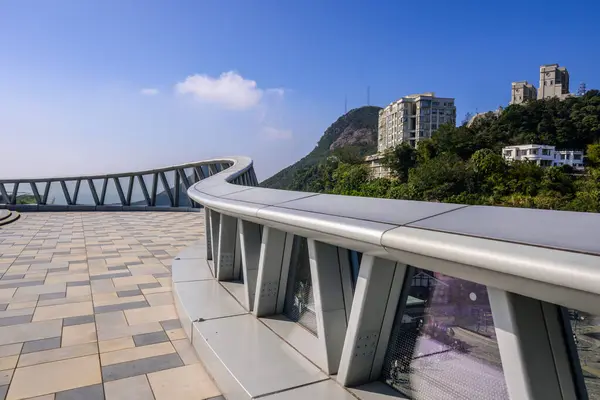 Hong Kong 'daki Victoria Tepesi' ne bakan metal parmaklıkları ve cam panelleri olan modern eğimli bir Peak Galleria çatısı..