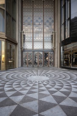 K11 MUSEA mall entrance with large glass doors, a geometric patterned window, and a geometric patterned pavement. The building has a sleek and minimalist design. clipart