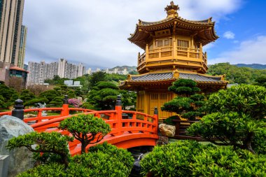 Karmaşık bir şekilde oyulmuş demiryolu ile kırmızı ahşap bir köprü altın pagoda, Mutlak Mükemmellik Pavyonu 'na götürür, Nan Lian Garden, Hong Kong' da siyah kiremitli bir çatı
