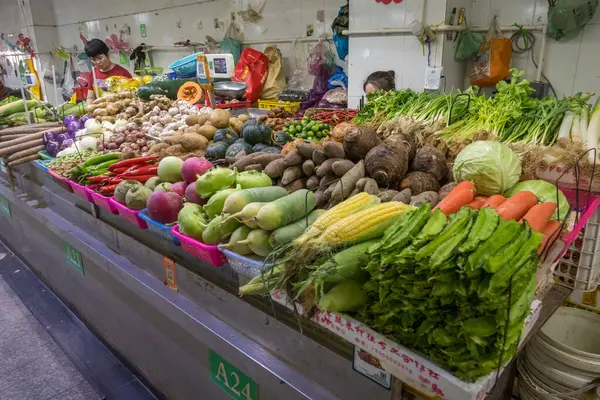  Sanya, Hainan, Çin - 16 Şubat 2024: Geleneksel bir yerel pazarda yapraklı yeşillikler, kökler ve yumrular da dahil olmak üzere çeşitli taze sebzeler sergilenmektedir. 