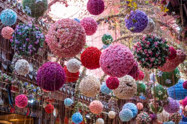 Çeşitli renklerde asılı çiçek küreleriyle süslenmiş bir tavan. Pembe, mor, kırmızı, beyaz, mavi ve yeşil. Teller tarafından askıya alınırlar ve canlı, tuhaf bir atmosfer yaratırlar..