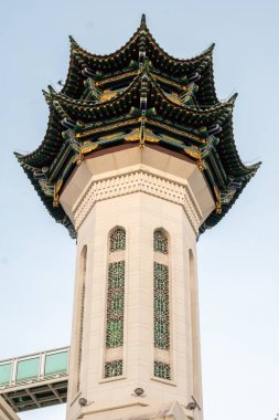 Sanya, Hainan, Çin 'de yeşil, mavi ve altın kaplamalı bir caminin minare kulesi. Kulede iki kemerli pencere ve kuleye bağlanan bir köprü var..