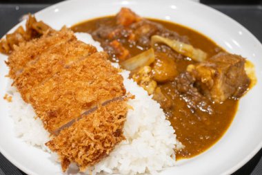 Bir tabak Japon körili pirinci yanında kızarmış tonkatsu domuz pirzolası ve zengin bir köri sosu servis edilir..