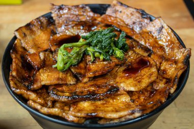 Lezzetli bir Buta Don kasesi. Izgara domuz dilimleri. Lezzetli bir sosla kaplanmış. 