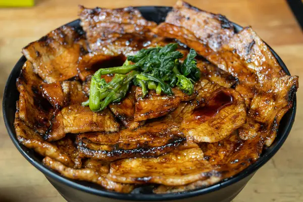 Lezzetli bir Buta Don kasesi. Izgara domuz dilimleri. Lezzetli bir sosla kaplanmış. 