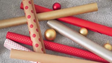 Genç bir kadın arkadaşları ve akrabaları için Noel hediyesi paketliyor. Kız kırmızı kağıtlı, renkli kurdeleli yeni yıl paketleri yapıyor. Noel süslemeleri, tatil sezonu hazırlıkları..
