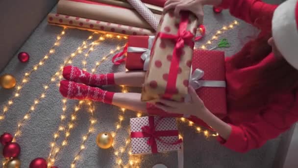 Μια Νεαρή Γυναίκα Πακετάρει Χριστουγεννιάτικα Δώρα Για Τους Φίλους Και — Αρχείο Βίντεο