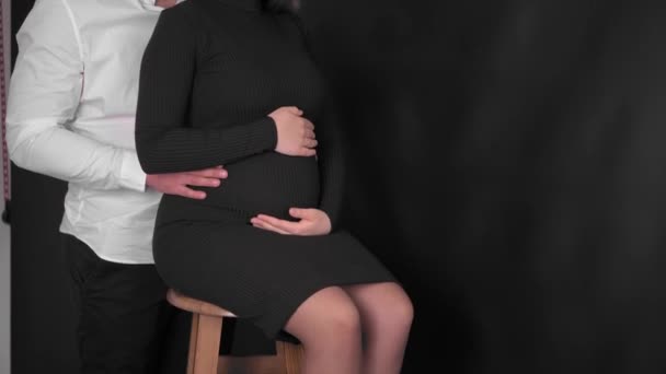 快乐的孕妇 大肚子在家里休息 怀孕的年轻女人和一个怀上孩子的男人年轻的孕妇爱抚她的肚子 这个年轻的家庭正在等待补给 — 图库视频影像