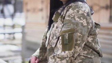 Askeri üniformalı bir kız. Ukrayna 'nın silah güçleri. Askeri kamuflaj üniformalı esmer kız. Bir kızın kurnaz bakışı..