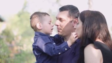 Mutlu genç bir aile parkta dinleniyor. Kocasıyla ve çocuğuyla birlikte bir eş doğada dinleniyor. Kavram: birlik, sevgi, karşılıklı anlayış, ortak ilgi alanı, birlikte zaman geçirme, boş zaman.