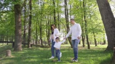 Mutlu genç bir aile parkta dinleniyor. Kocasıyla ve çocuğuyla birlikte bir eş doğada dinleniyor. Kavram: birlik, sevgi, karşılıklı anlayış, ortak ilgi alanı, birlikte zaman geçirme, boş zaman.