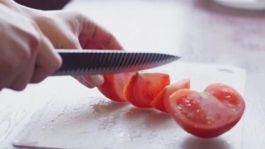 Taze sebze salatası. Mutfakta sağlıklı yemek pişirmek. Vejetaryen diyeti. Turplar, domatesler, marul, kokulu yeşillikler ve zeytinlerle sağlıklı bir öğle yemeği yakın. Kadın salatayı keser ve karıştırır..