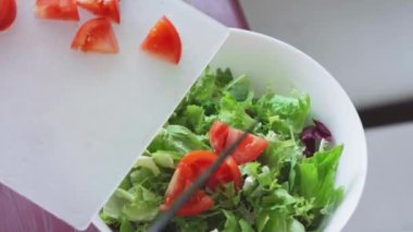 Taze sebze salatası. Turplar, domatesler, marullar, otlar ve zeytinlerden oluşan sağlıklı bir öğle yemeği. Mutfakta sağlıklı yemek pişirmek. Vejetaryen diyeti. Bir kadın salata karıştırıyor..