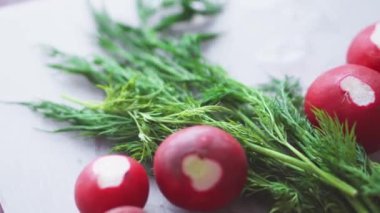 Taze sebze salatası. Mutfakta sağlıklı yemek pişirmek. Vejetaryen diyeti. Turplar, domatesler, marul, kokulu yeşillikler ve zeytinlerle sağlıklı bir öğle yemeği yakın. Kadın salatayı keser ve karıştırır..
