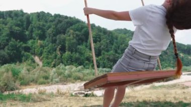 Kızıl saçlı bir kız doğada salıncakta sallanıyor. Bir kadın yaz parkında rahatlar ve eğlenir. Hayal kurmayı, rahatlamayı ormanda salıncakta sallanmayı ve çocukluğunu hatırlamayı sever..