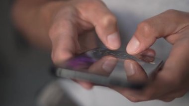 Akıllı telefondaki hayat. Genç bir adam cep telefonuna bakar ve sosyal ağlara yakından bakar. Rahat yetişkin bir adam akşamları cep telefonu uygulaması okuyor. Cep telefonu parmaklarına dokun..