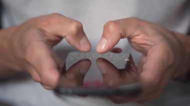 Genç bir adam akıllı telefonu kullanarak bir mesaj yolluyor, yakın plan. Cep telefonun elinde dursun. Mobil Teknoloji 5G konsepti ve insanların ekranda mesajlaşması ve okuması. Göz gezdir ve al.