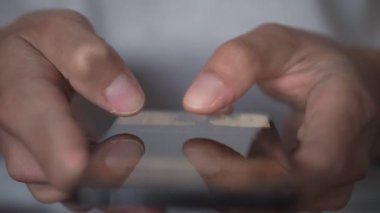 Genç bir adam akıllı telefonu kullanarak bir mesaj yolluyor, yakın plan. Cep telefonun elinde dursun. Mobil Teknoloji 5G konsepti ve insanların ekranda mesajlaşması ve okuması. Göz gezdir ve al.