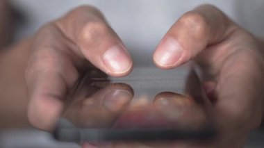 Akıllı telefondaki hayat. Genç bir adam cep telefonuna bakar ve sosyal ağlara yakından bakar. Rahat yetişkin bir adam akşamları cep telefonu uygulaması okuyor. Cep telefonu parmaklarına dokun..