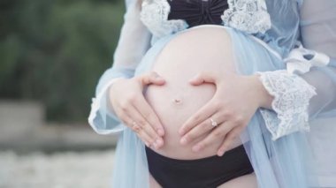 Nehrin yanındaki parkta güzel hamile bir kadın. Müstakbel anne bir bebeğin doğmasını bekliyor, ilk çocuğunun. Genç bir kadının hamileliği ve mutluluğu. Yazın parkta dinlen..