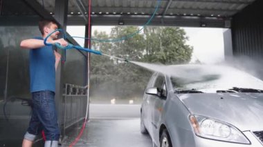 Mutlu çift araba yıkıyor ve güneşli bir günde bahçede eğleniyor. Bir adam ve bir kadın oto yıkamada. Kız ve Oğlan arabayı köpükle ve suyla temizleyip paçavralarla silin..