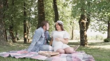 Güzel hamile kadın ve kocası göbeğine sarılıyorlar. Müstakbel anne ve babaları ilk çocuklarının doğmasını bekliyorlar. Genç bir ailenin hamileliği ve mutluluğu..